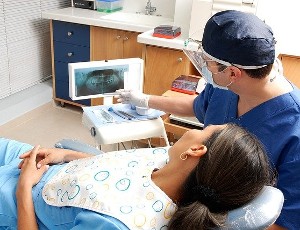 Dentysta pokazujący pacjentce zdjęcie RTG zębów.